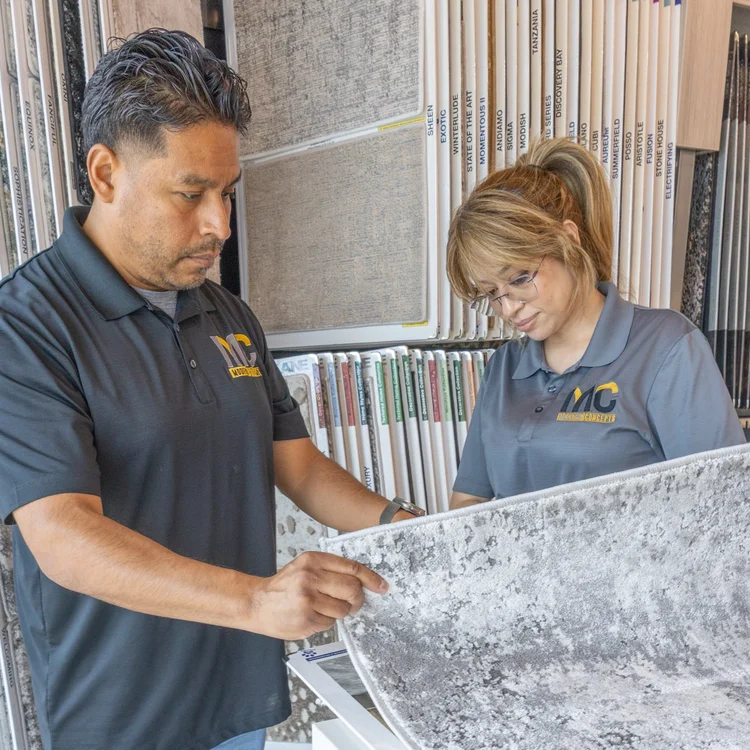 Modern Concepts Design team reviewing a carpet sample with a client